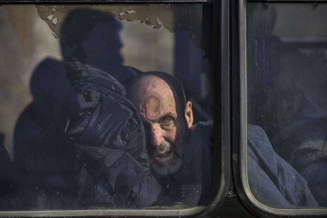 Un hombre mira por la ventana de un autobús después de ser evacuado de un pueblo cercano a Kiev ocupado por el ejército ruso. 