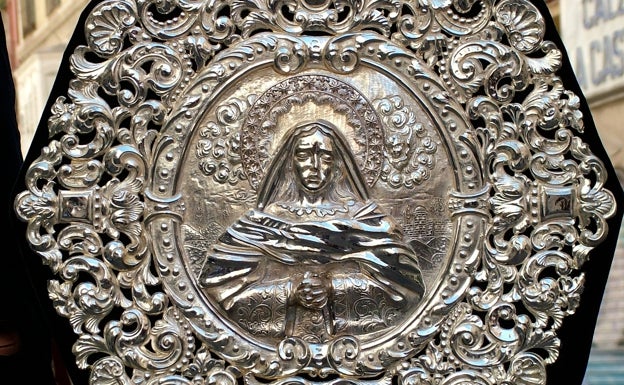 Placa del guión de la Virgen de la Soledad de Mena. 