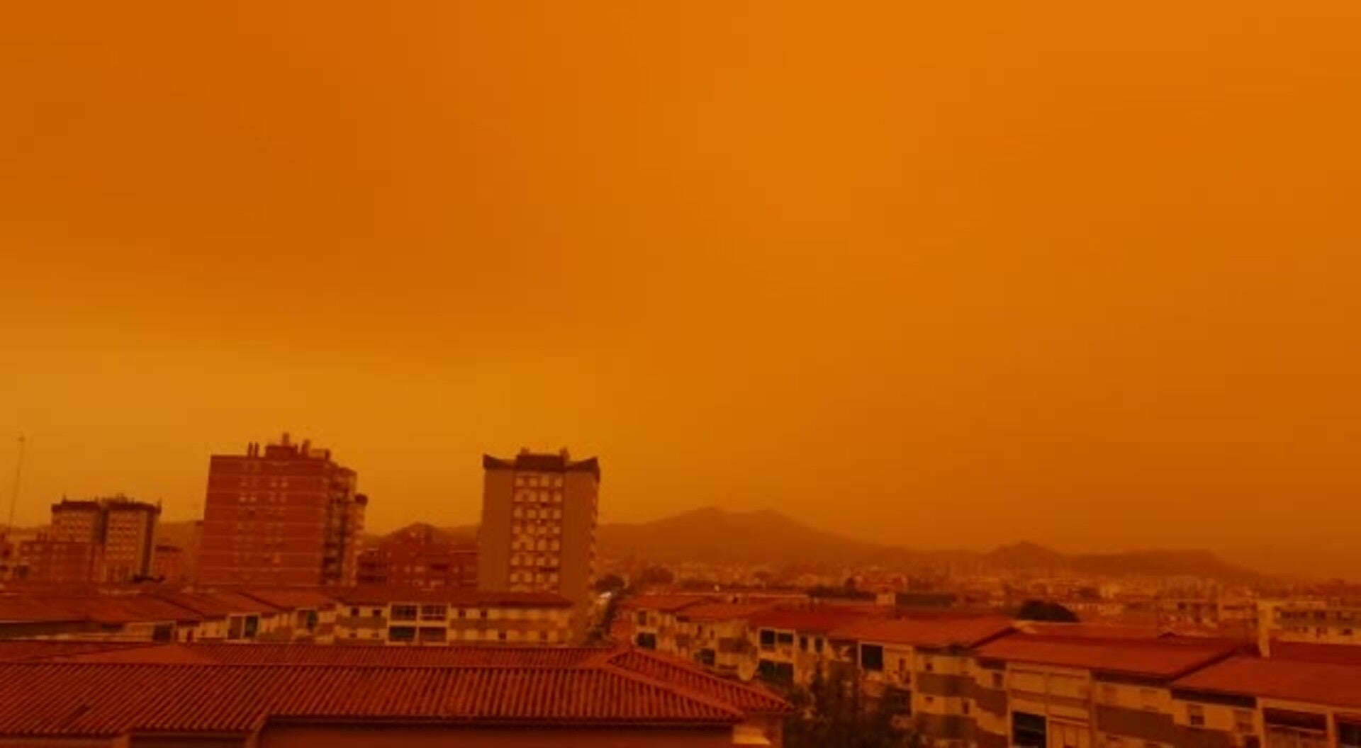 La calima vuelve a teñir el cielo de Málaga de un color naranja intenso