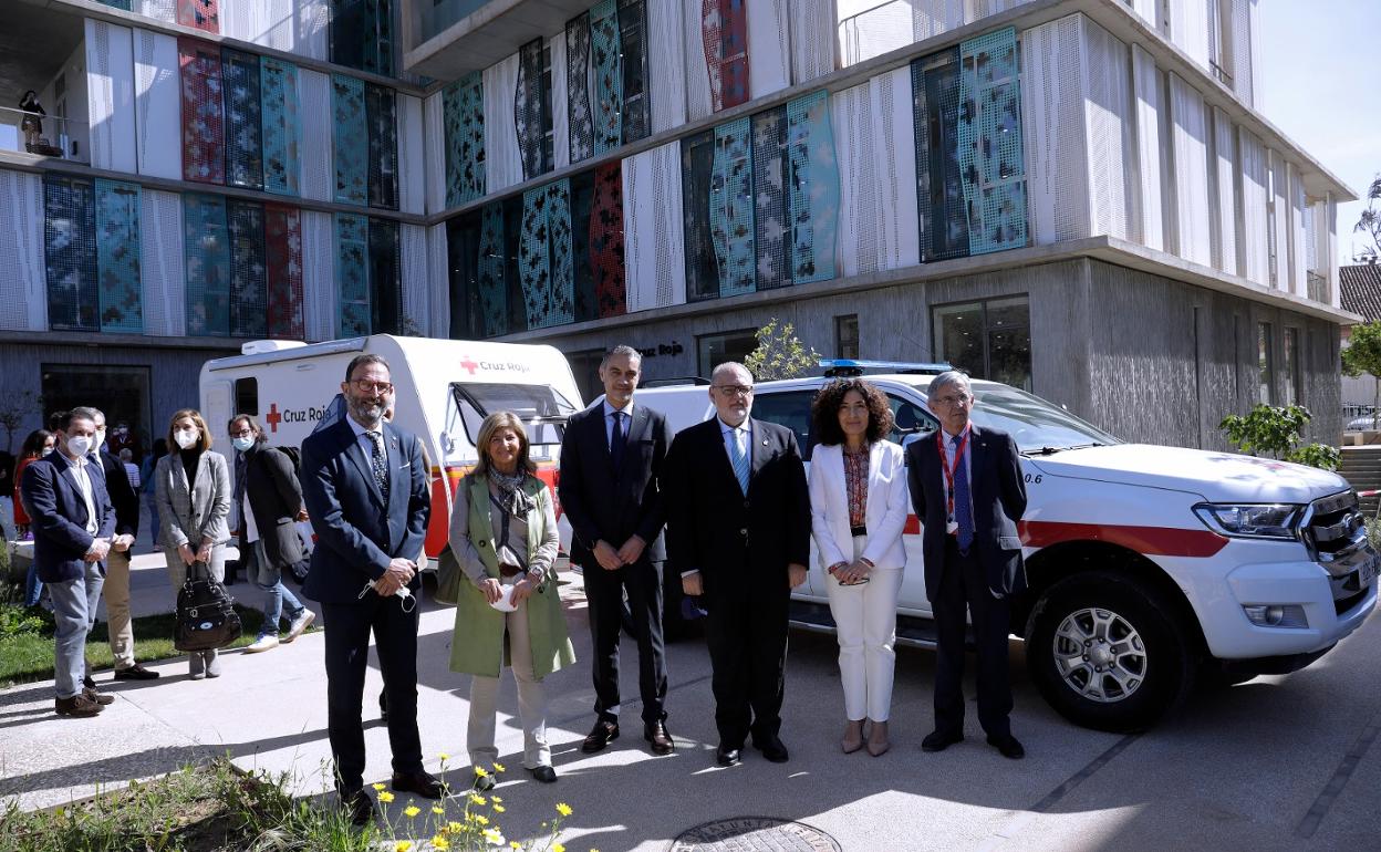 Autoridades y personal de Cruz Roja, junto a la unidad móvil de cribado. 