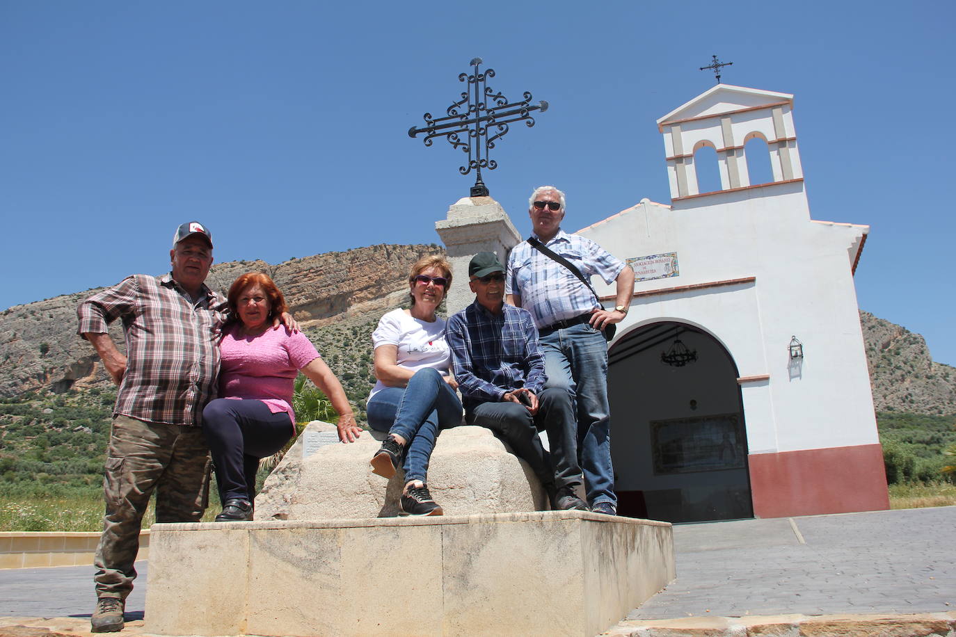 En 1972 los vecinos se vieron obligados a abandonar su pueblo, que desapareció bajo las aguas del pantano del Guadalteba. En la imagen, varios vecinos posan para SUR en la peana, un símbolo y punto de encuentro de su pueblo natal que la Asociación Rosario de Peñarrubia se empeñó en recuperar junto a la ermita que han construido junto al embalse.