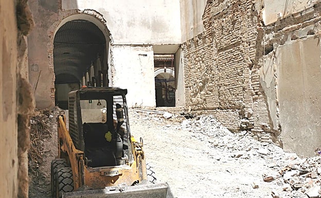 Imagen principal - En la primera foto, una excavadora de la obra de remodelación que ya ha arrancado en el Convento de San Agustín. En la segunda, vista de uno de los patios del inmueble y, en la última, galería mallada del claustro del edificio. 