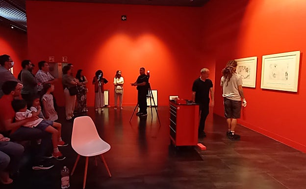 Imagen principal - En la primera foto, los visitantes asisten a la colocación de unas piezas en la exposición. En la segunda , cajas en las se han transportado las obras al Museo Ruso y, en la última, un momento de la visita.