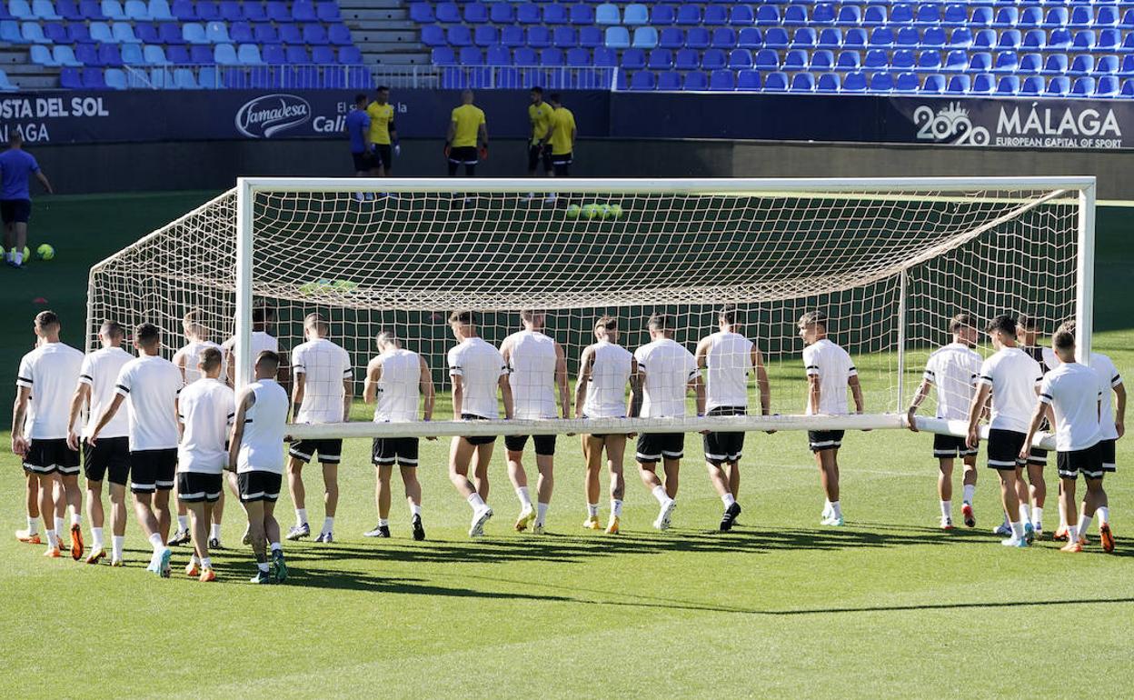 Los jugadores trasladan una portería en La Rosaleda 