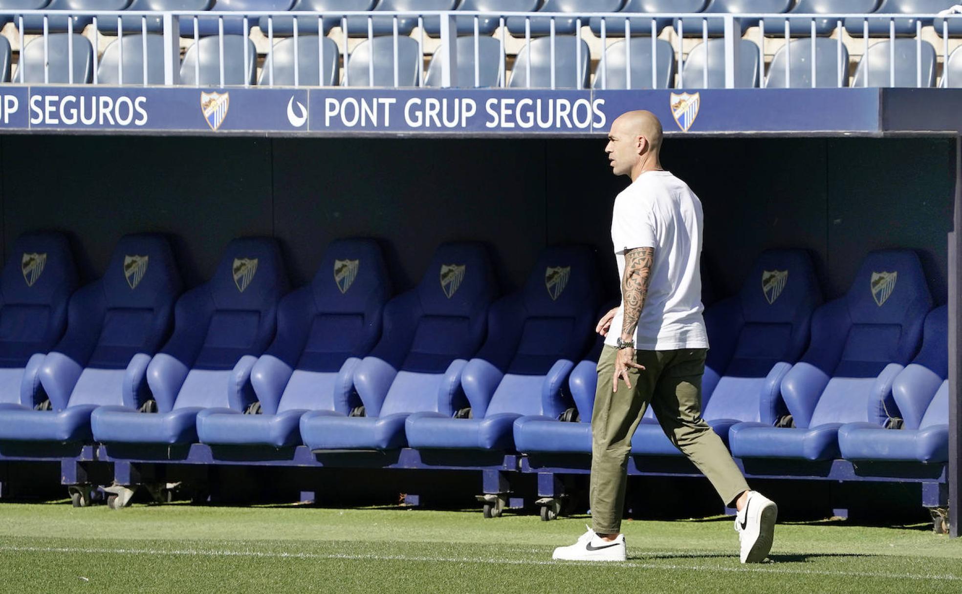 El director deportivo del Málaga, Manolo Gaspar, pasea por el estadio de La Rosaleda durante un entrenamiento reciente del equipo.