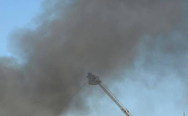 Imagen principal - Incendio Málaga: Un incendio afecta a una nave de patinetes ubicada en el polígono Azucarera