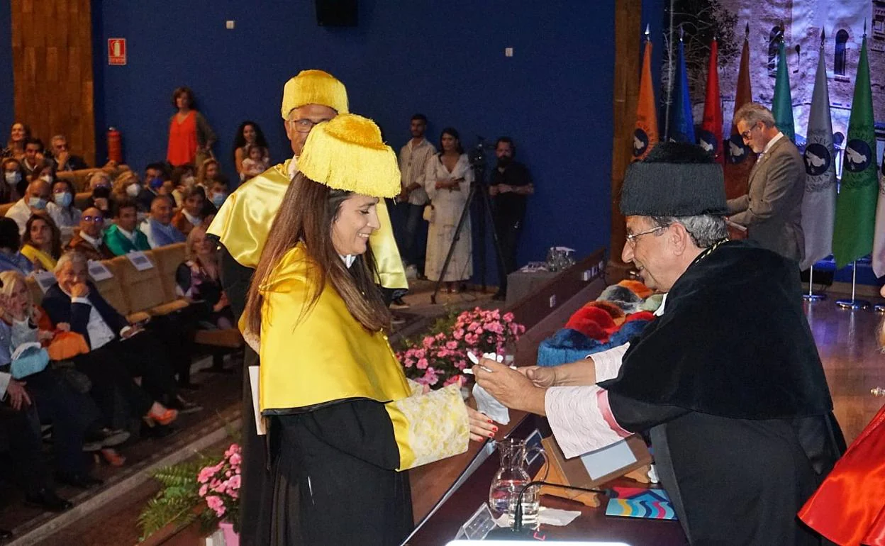 El rector, José Ángel Narváez, entrega los guantes blancos, distintivo de pureza, a una doctora en Medicina. 