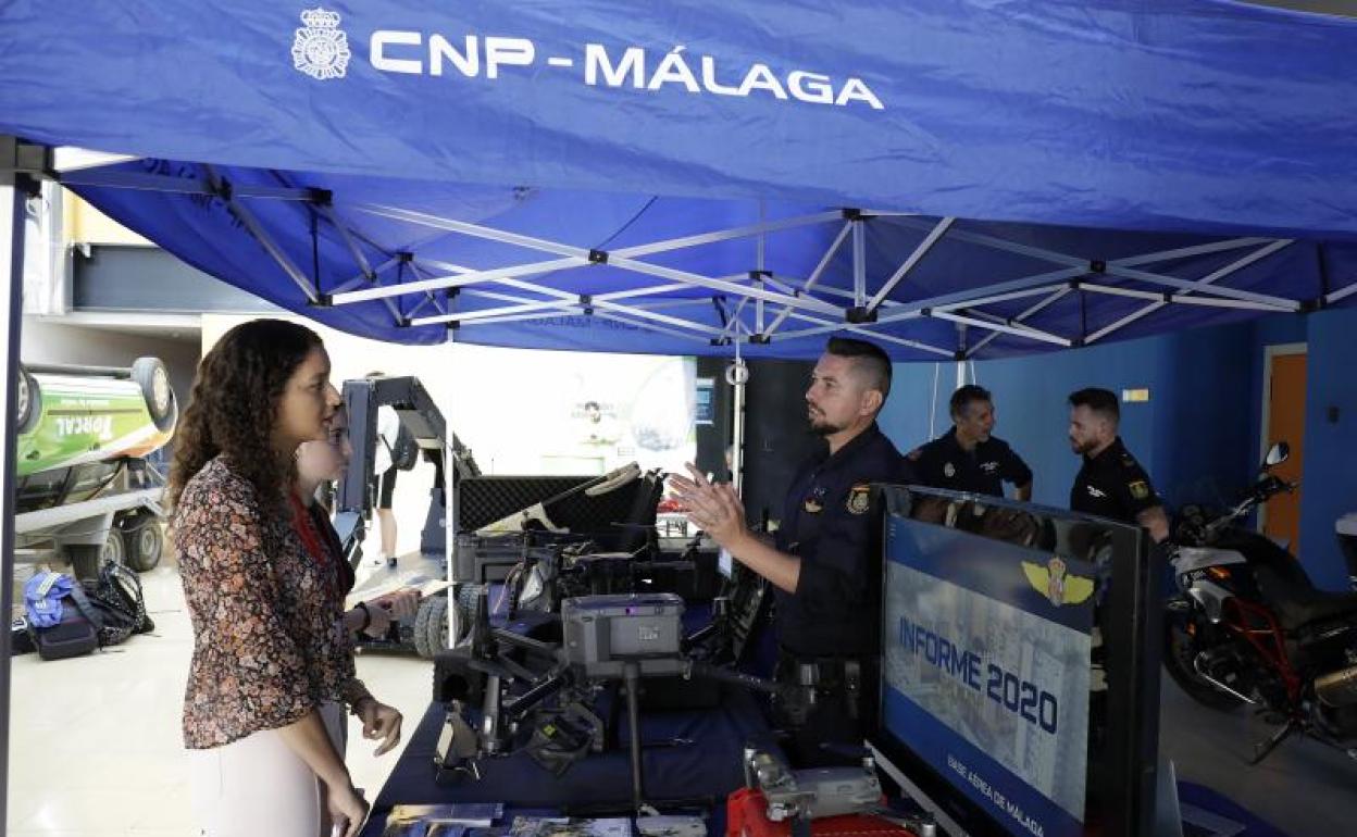 Unas jóvenes reciben información en el puesto de la Policía Nacional. 