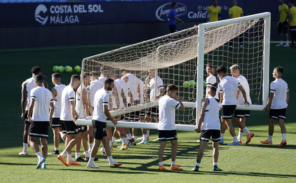 Los jugadores del Málaga trasladan una portería en el último entrenamiento de la temporada. 