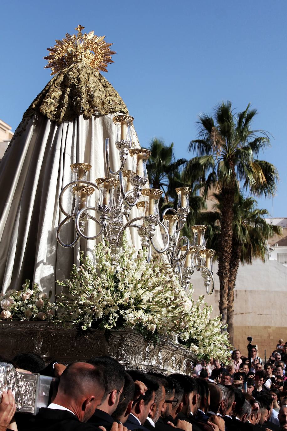 Detalles de la procesión de la Virgen de la Trinidad por las calles de su barrio. 