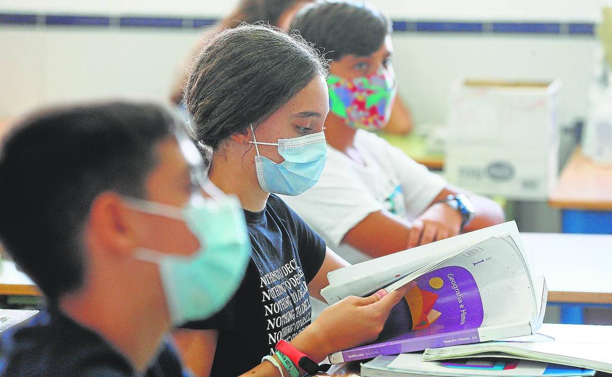 Una alumna ojea el libro de Geografía e Historia, en el primer día de curso en el IES Jarifa. 