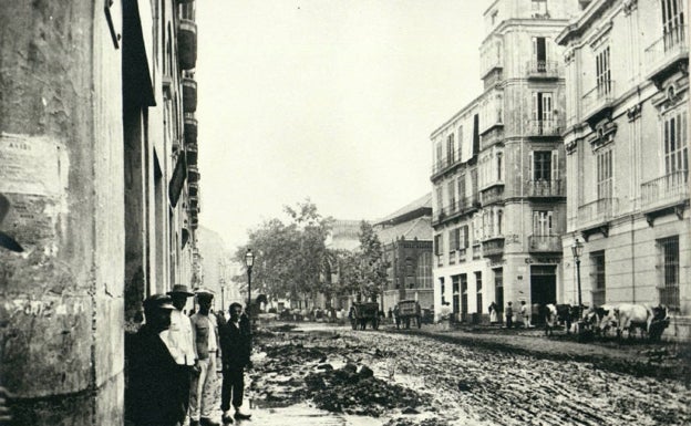 Imagen principal - Arriba, aspecto de la zona de Atarazanas. Abajo, el barrio de la Trinidad lleno de barro. Al lado, portal de calle Carreterías con una señal de hasta dónde llegó el agua. 