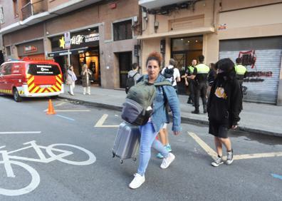 Imagen secundaria 1 - Arriba, estado del interior del edificio. Abajo, algunas familias durante el desalojo y una de las ambulancias que acudieron a socorrer al herido. 