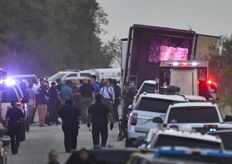 Policías y forenses trabajan en el camión lleno de migrantes que fue abandonado en una carretera de Texas.