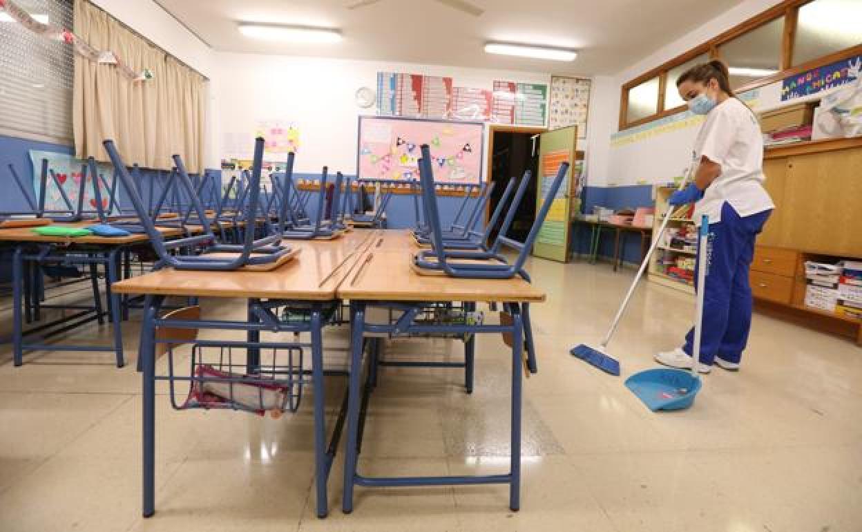 Una limpiadora trabaja en un aula de un colegio de la capital malagueña en una imagen de archivo. 