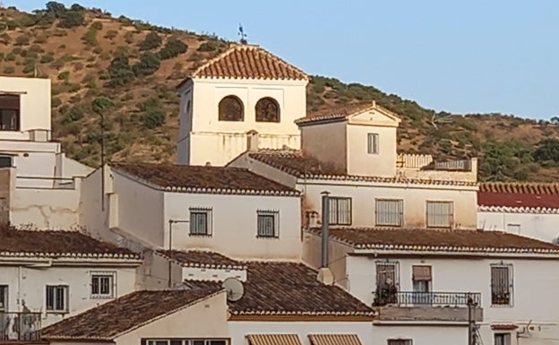 Imagen de la torre de la iglesia de Santa Ana de Totalán con los restos de barro de la calima. 