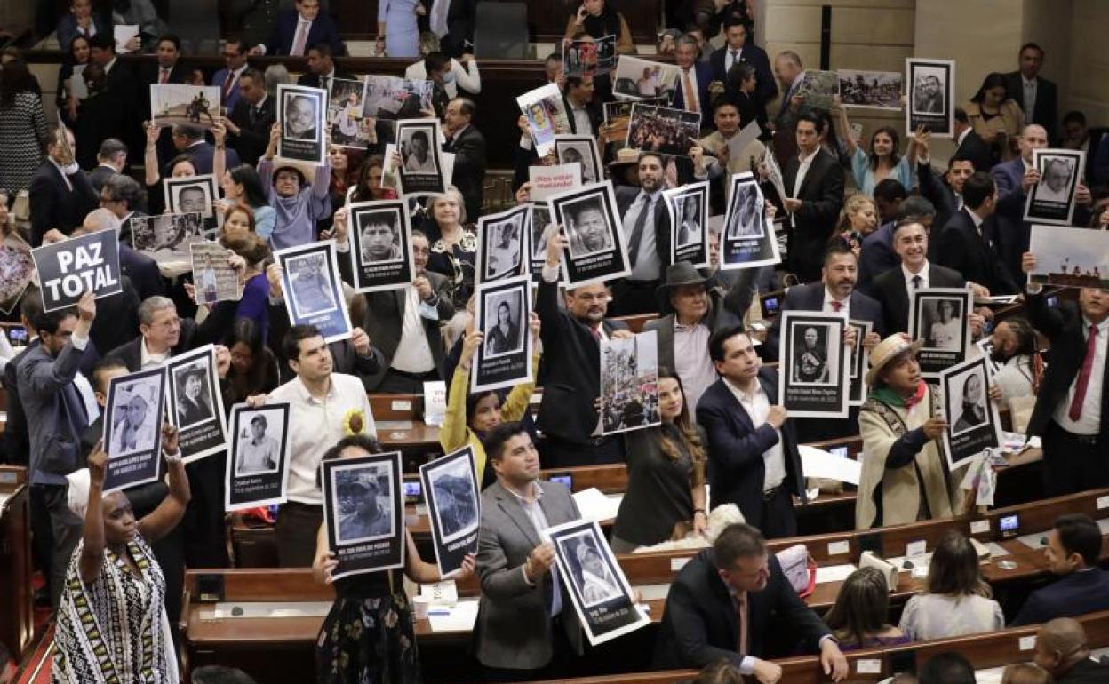 Diputados de izquierdas muestran a Iván Duque retratos de líderes sociales asesinados por la violencia en Colombia. 