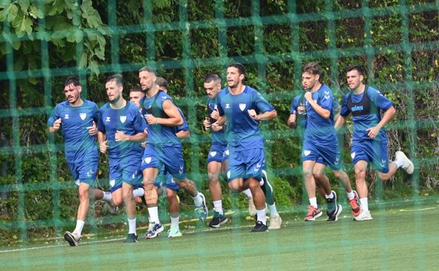 Jugadores del Málaga realizan carrera continua en el campo de fútbol Atalaya de Estepona.