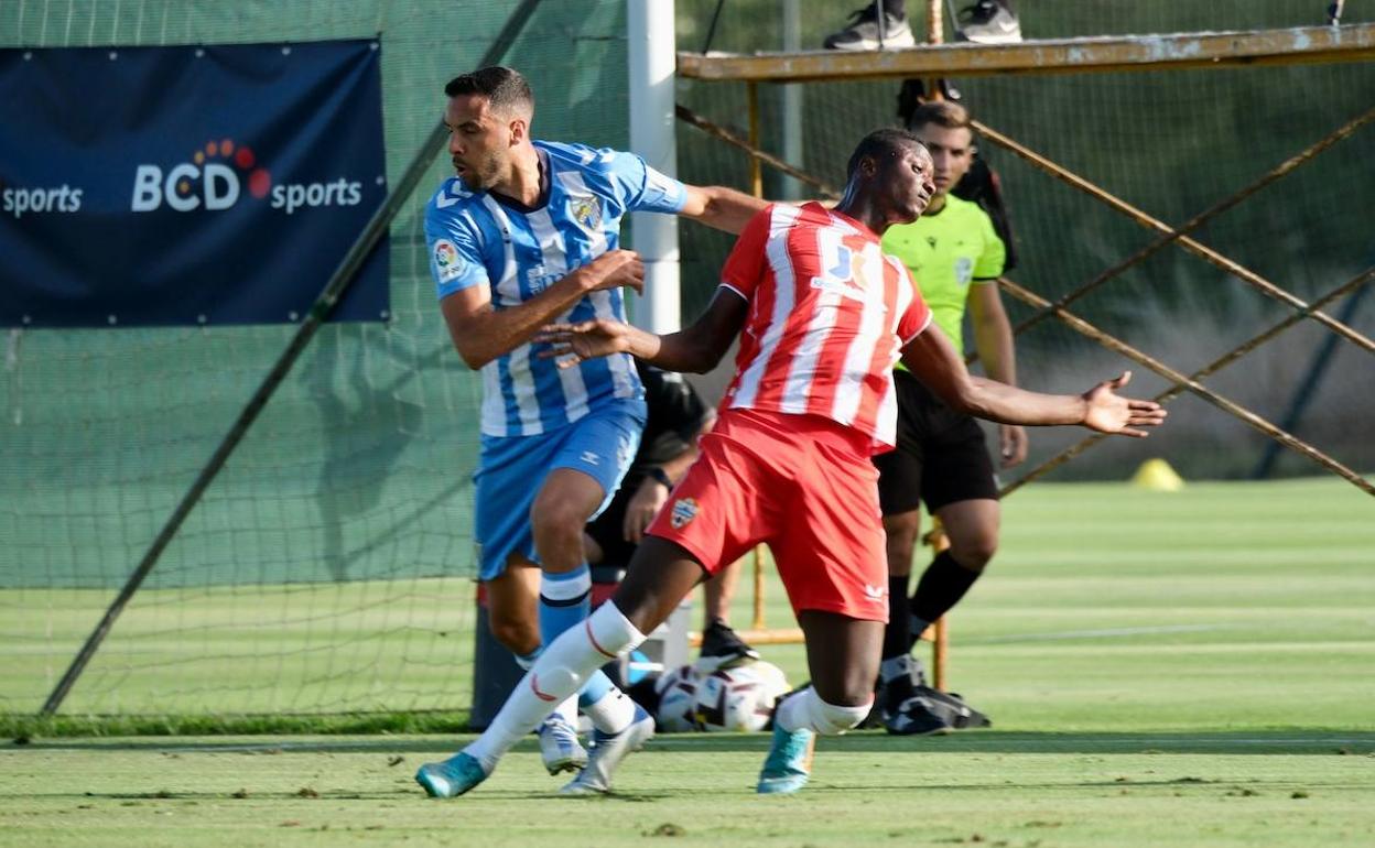 El jugador del Málaga, Esteban Burgos, pugna con Umar Sadiq, del Almería, en un lance del juego.