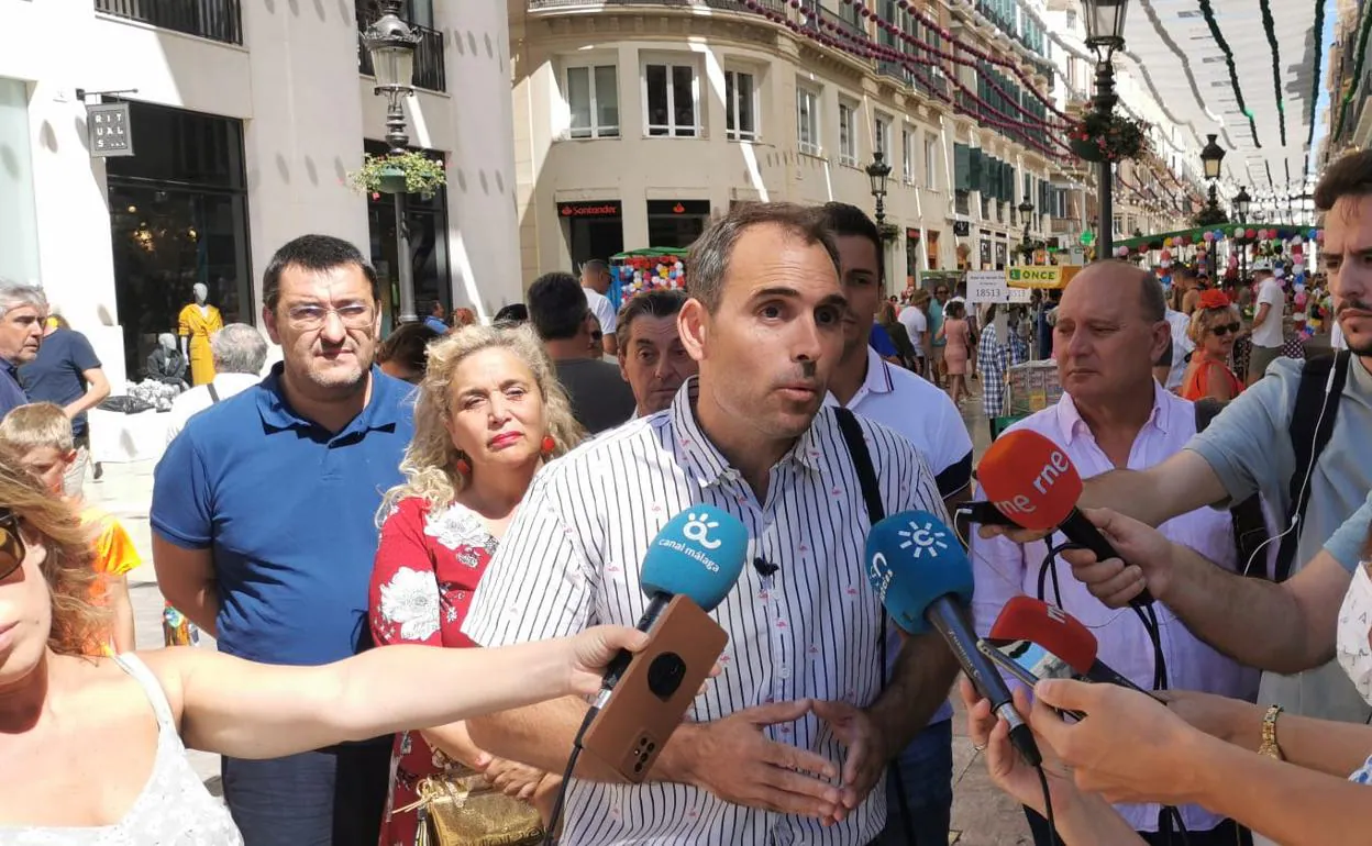 El coordinador regional de IU, Toni Valero, atiende a los medios en la portada de la Feria, en la calle Larios. 