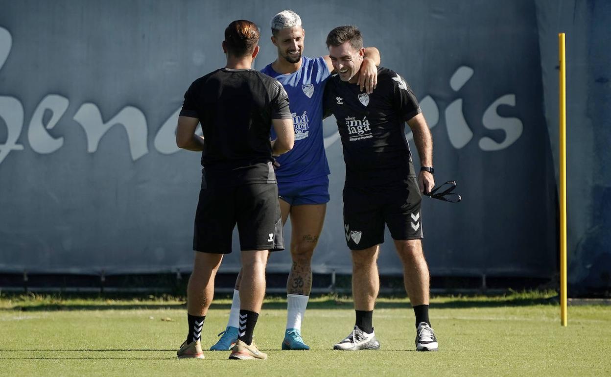 El jugador del Málaga, Fran Sol, durante el entrenamiento de este jueves junto al entrenador Pablo Guede. De espaldas, el readaptador Toni Tapia.