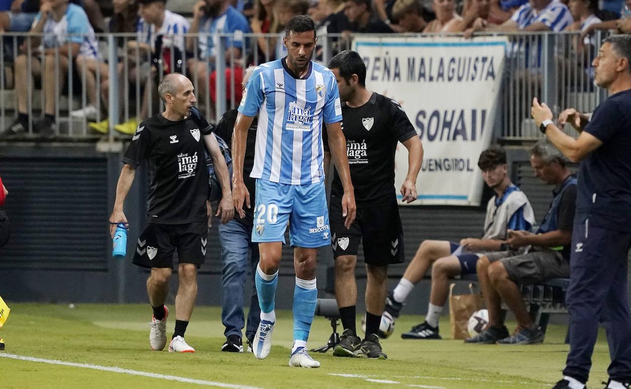 El jugador del Málaga, Esteban Burgos, se retira sustituido en el partido contra Las Palmas por una lesión muscular.