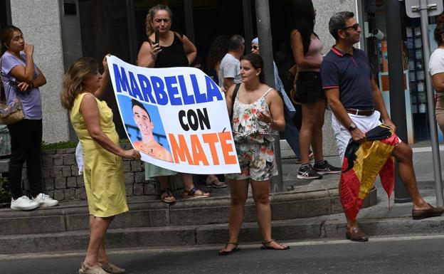 Dos espectadoras muestran una pancarta de apoyo al malagueño Luis Ángel Maté durante el paso de la prueba por Marbella.