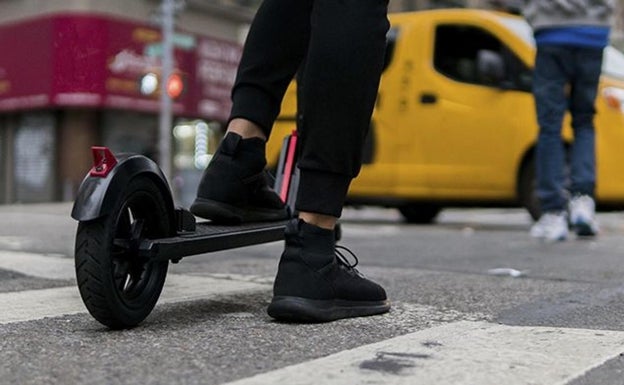 Un joven en un patinete en un cruce de calles.