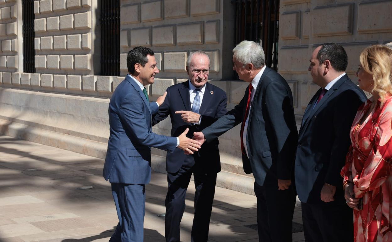 Juanma Moreno saluda al presidente del Comité Ejecutivo del BIE de París, Alain Berger, en presencia del alcalde de Málaga. 