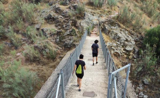 Imagen principal - Para acceder a la presa hay un trazado protegido con vallas metálicas. El descenso a la gruta se hace a través de un pronunciado recorrido de escaleras. Entrada de la Cueva de Hundidero.