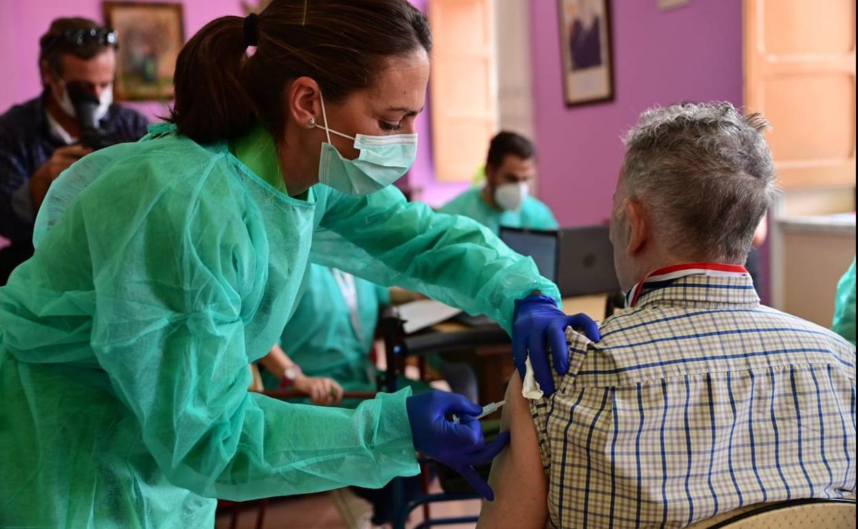 Una profesional de enfermería pone una vacuna contra la gripe. 