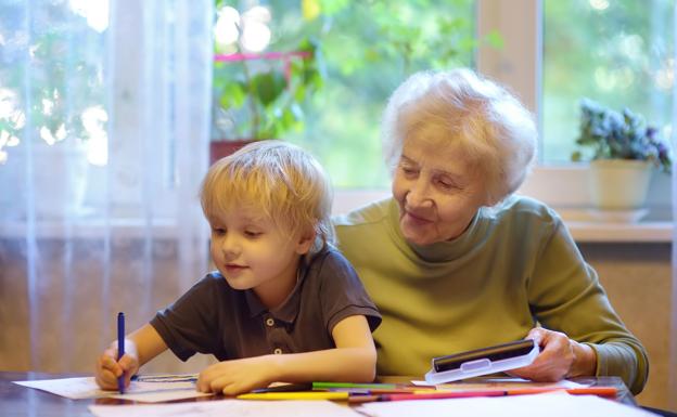 Una abuela ayuda a su nieto a hacer los deberes.