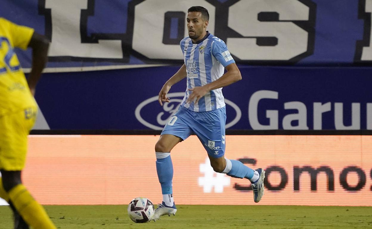 Burgos conduce un balón durante un partido esta temporada en La Rosaleda.