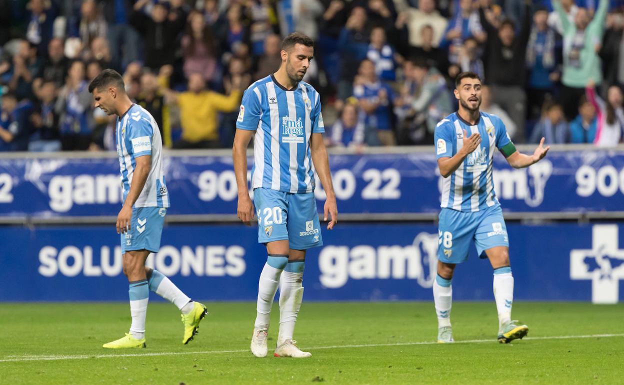 Los jugadores del Málaga Juanfran, Esteban Burgos y Luis Muñoz (d) durante el partido contra el Oviedo.