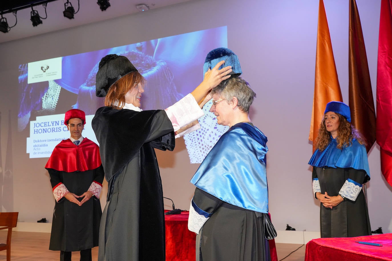 La rectora de la Universidad del País Vasco, Eva Ferreira, pone el birrete de doctora a Jocelyn Bell. 