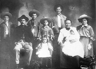 Imagen secundaria 1 - Arriba, uno de los buques, antes de zarpar del puerto de Málaga; abajo, a la izquierda, una de las familias que emigraron, fotografiada en Hawái, y a la derecha, cartel del congreso internacional de Cáceres. 