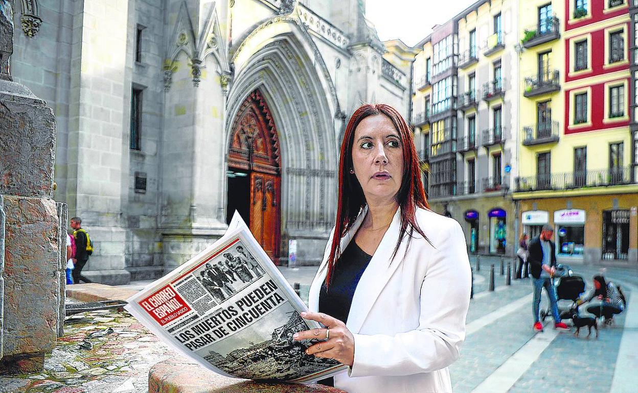 Dolores Redondo hojea un ejemplar de 'El Correo' de 1983 que informaba del alcance de las inundaciones en Bilbao