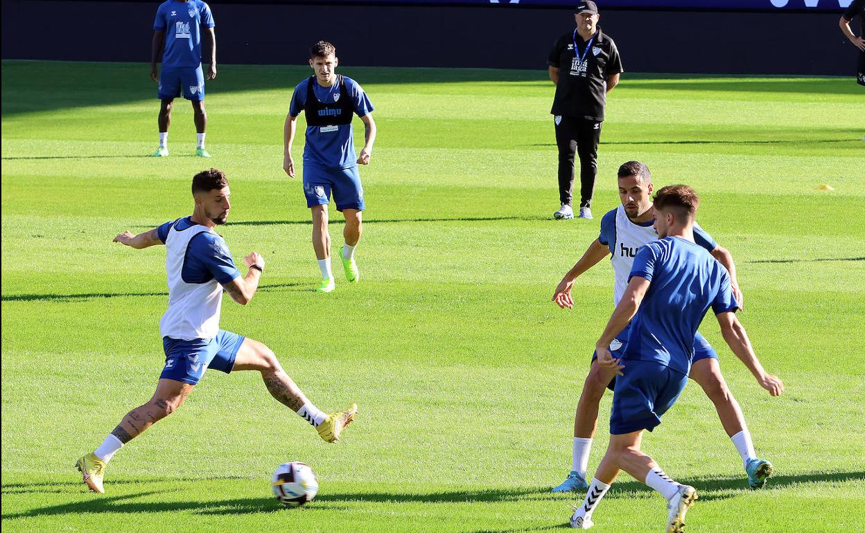 Jugadores del Málaga durante el entrenamiento del jueves, con pepe Mel al fondo. 