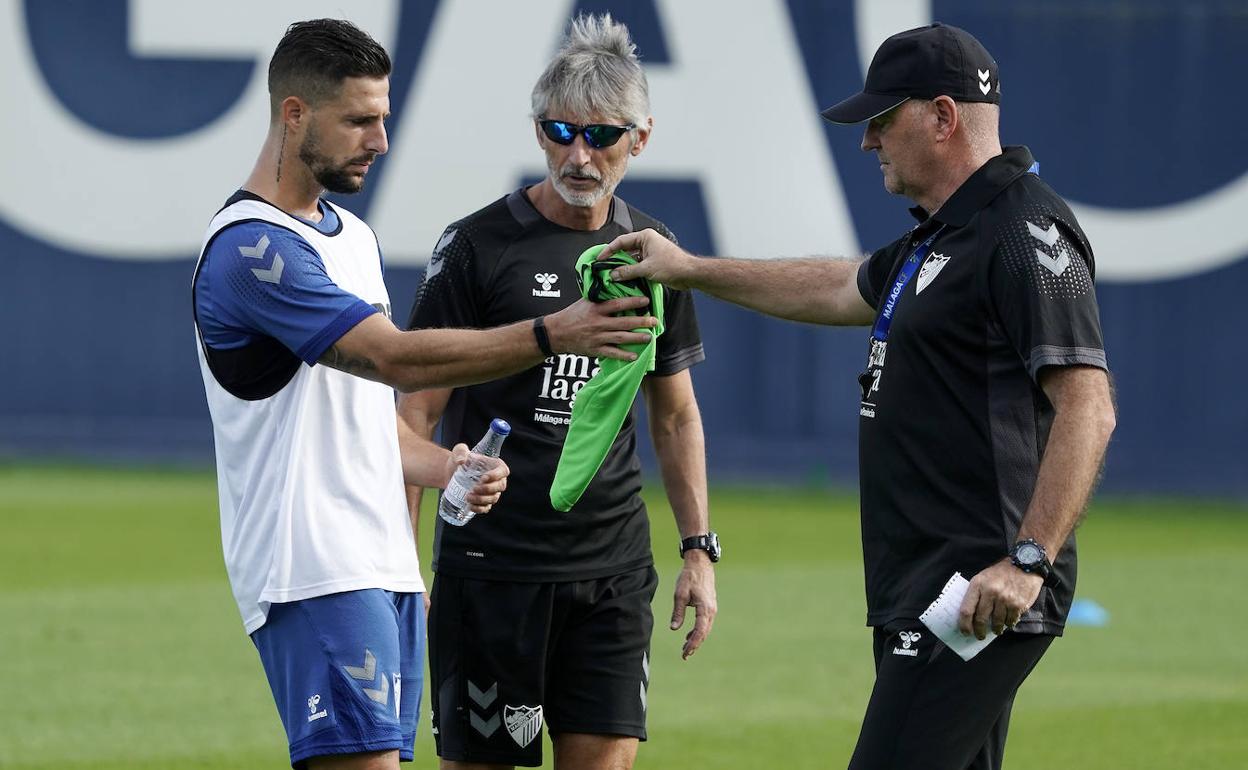 Pepe Mel le ofrece uno de los petos a Fran Sol en el entrenamiento de este lunes. 