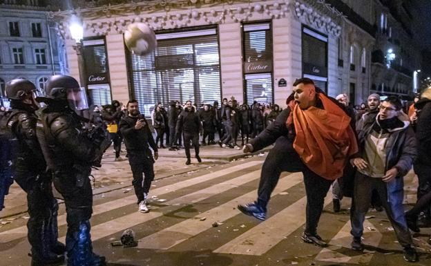 Aficionados marroquíes se enfrentan a los gerdarmes galos en París tras la victoria de su país el sábado ante Portugal