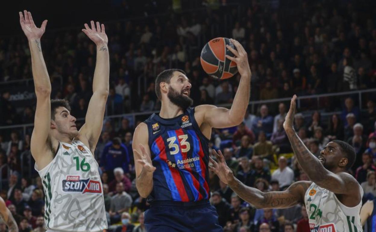 Mirotic se hace con un rebote ante dos jugadores del Panathinaikos. 