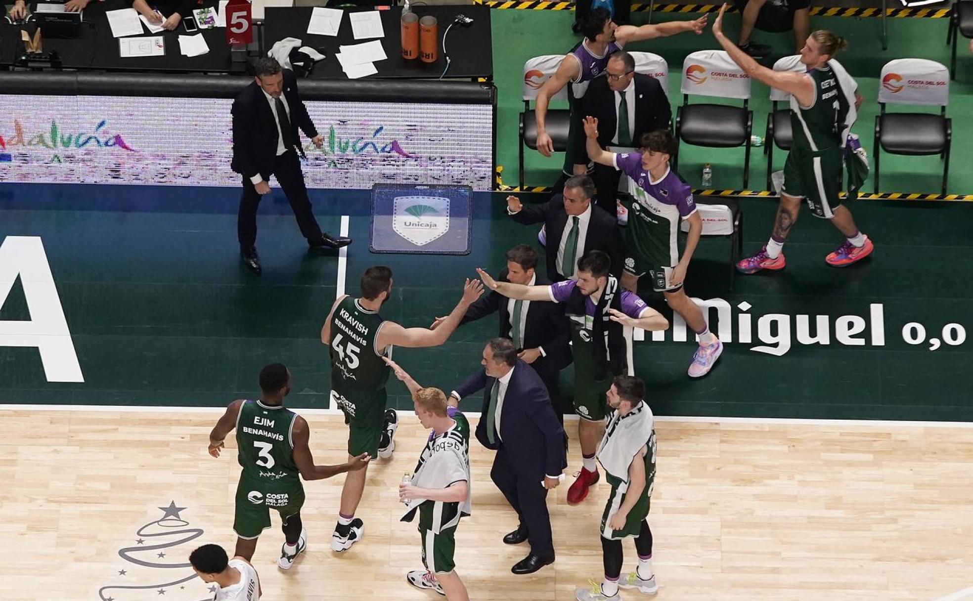 Los jugadores del Unicaja son felicitados por sus compañeros y los técnicos en un tiempo muerto. 