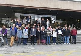 Un grupo de padres y madres, con concejales del PSOE y Unidas Podemos, ante el edificio administrativo, donde estaban reunidas empresa y trabajadores.