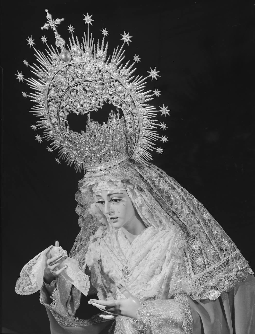 El objetivo capta a la Virgen de la O, titular mariana de la Cofradía de los Gitanos, tal y como fue ataviada para su bendición en 1970 por el diseñador cofrade Juan Bautista Casielles del Nido, figura clave en la llegada de esta imagen a Málaga, puesto que ejercía la representación, precisamente en Málaga, del autor de la talla, el escultor Francisco Buiza. De hecho, fueron traídas al mismo tiempo desde el taller de Buiza tanto esta imagen como la actual Virgen del Traspaso y Soledad de Viñeros. La Dolorosa de los Gitanos lució para esa ocasión la corona de la Virgen de las Penas, con la que también estaba especialmente vinculado Casielles.