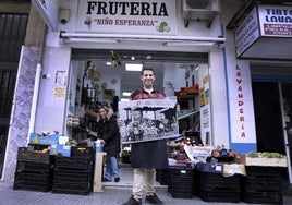 Alejandro Carrillo posa delante de la frutería junto a su mujer Rocío Torres.