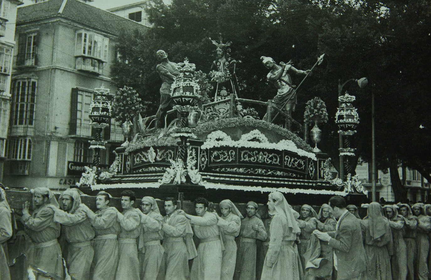 El tallista malagueño Pedro Pérez Hidalgo talló en 1956 unos artísticos faroles para los ángulos del trono del Señor, que vinieron a sustituir a unos candelabros metálicos dispuestos en el conjunto del taller valenciano de Orrico. Estos faroles, de gran tamaño, presentaban un cuerpo de espiral de inspiración salomónica, como se aprecia en la instantánea que se acompaña. El grupo escultórico de la Puente del Cedrón se encontraba en aquellos momentos en la Alameda. Obsérvese el grosor de los varales de madera que servían para portar el trono.