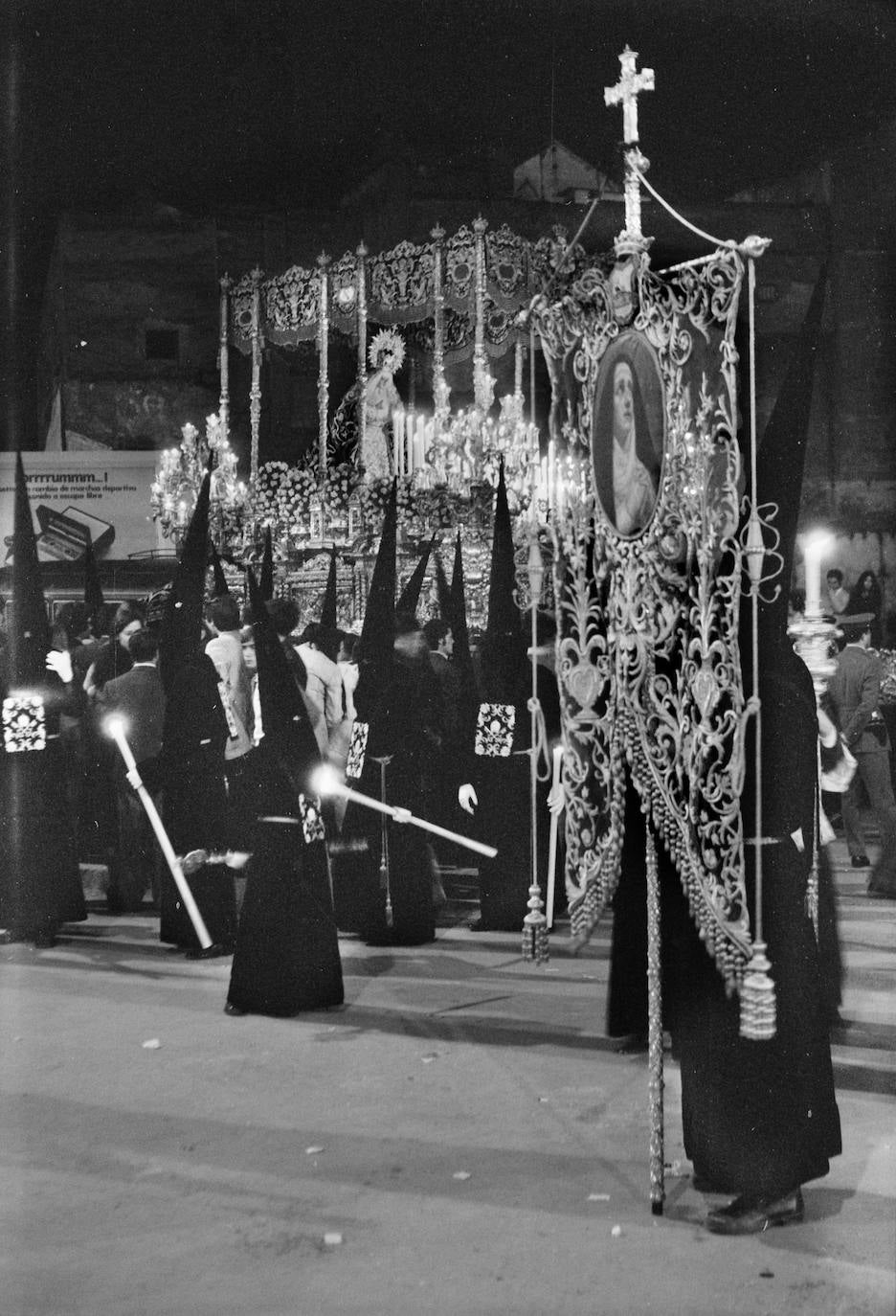 La Virgen de los Dolores Coronada inicia su desfile procesional. Al fondo se aprecian los restos de un barrio del Perchel que quedó muy transformado con la prolongación de la Alameda Principal.