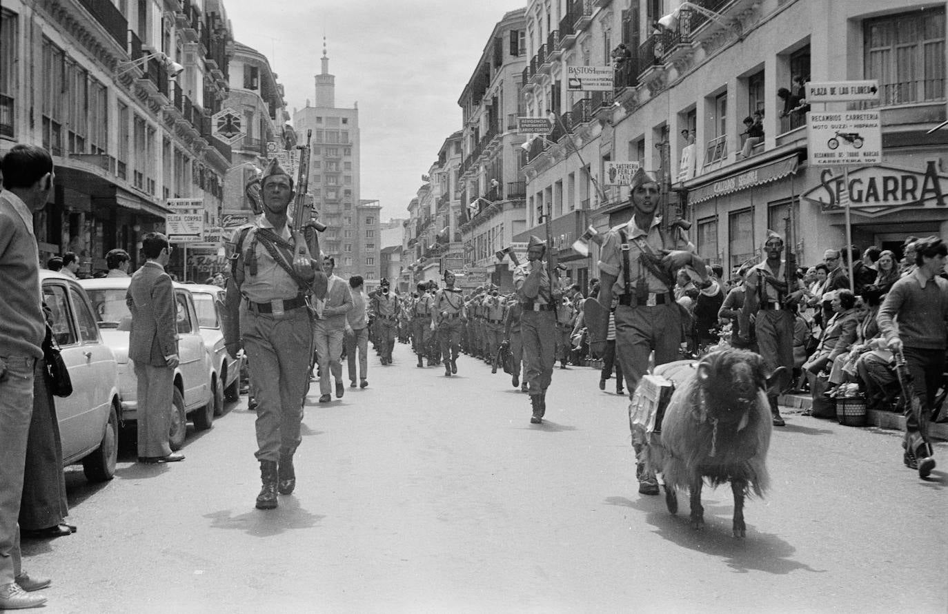 Año 1972. Calle Larios abierta a la circulación de vehículos. Parece que pasó hace muchísimo tiempo. La fotografía tiene, sin quererlo, sabor añejo, casi sepia. Momento del desfile de la Legión, tras el desembarco, en la mañana del Jueves Santo.