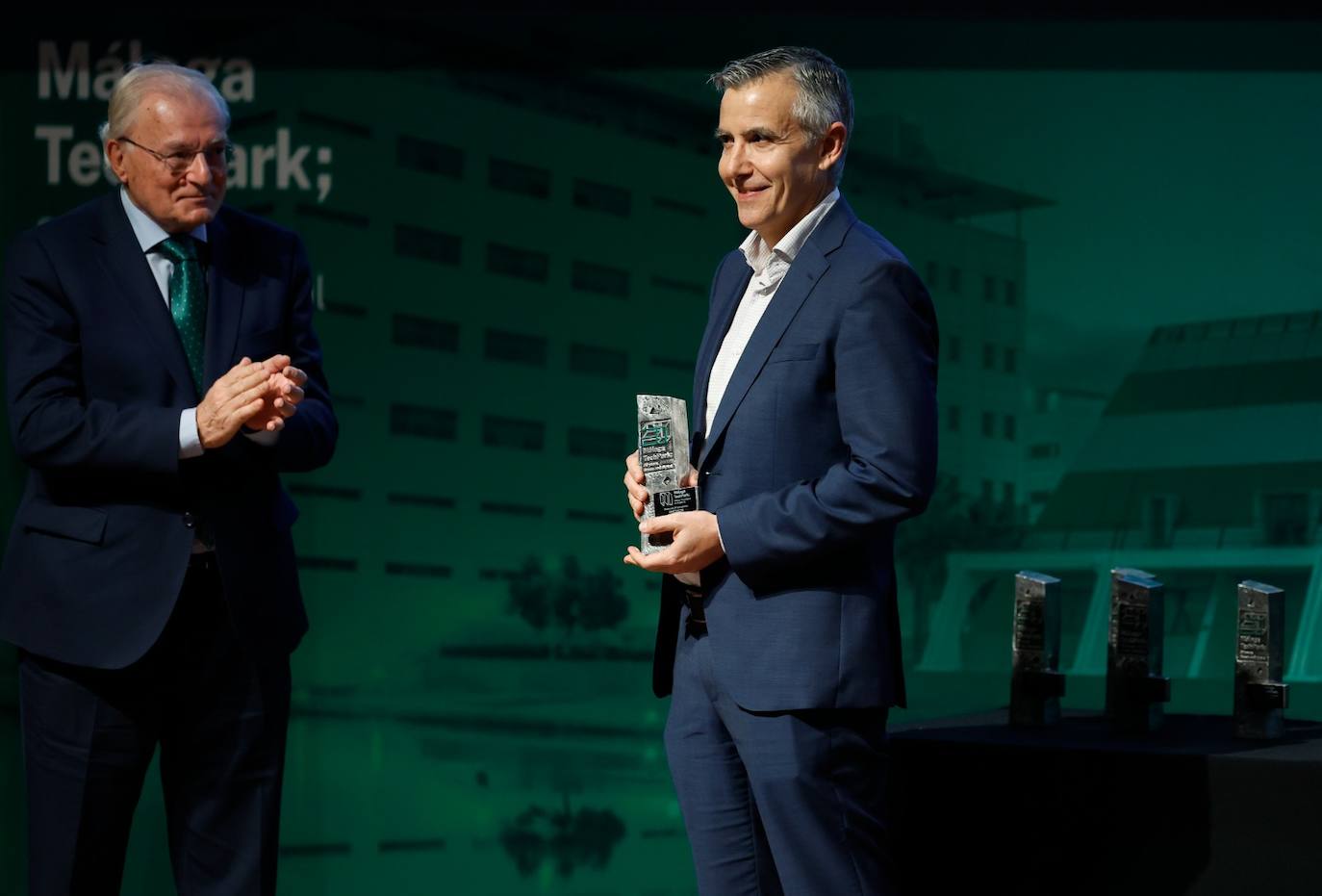 El presidente de Unicaja, Manuel Azuaga, aplaude al managing director de Accenture, Toni de la Prieta, por el reconocimiento obtenido. 