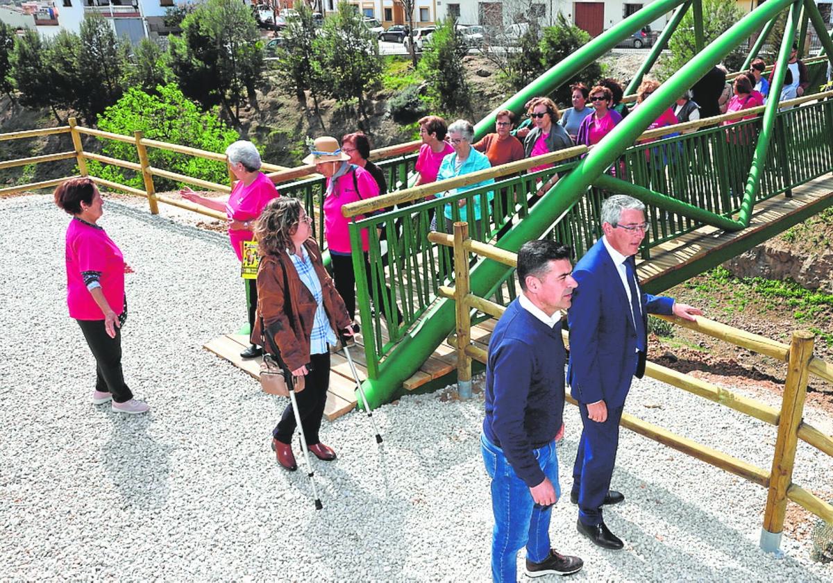 El presidente de la Diputación y el alcalde de Riogordo, ayer con vecinos, en la nueva pasarela peatonal.